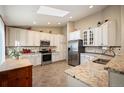 Bright kitchen featuring granite countertops, stainless steel appliances, and plenty of storage space, perfect for cooking and entertaining at 6480 Moss Cir, Arvada, CO 80007