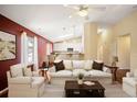 Bright living room with vaulted ceilings, skylights, and an open floor plan to the modern kitchen at 6480 Moss Cir, Arvada, CO 80007
