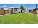 Backyard showcasing a green lawn, fence, and additional storage shed at 7826 Joan Dr, Denver, CO 80221
