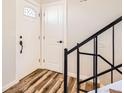 Bright foyer with new vinyl flooring, featuring a staircase with black iron railing at 15510 E Bates Ave, Aurora, CO 80013