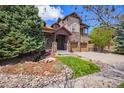 Beautiful two-story home with a stone facade, complemented by a lush green lawn and mature landscaping at 24273 E Fremont Dr, Aurora, CO 80016