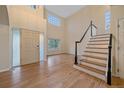 Bright foyer featuring hardwood floors and a staircase with a black handrail at 6393 S Richfield St, Aurora, CO 80016