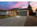 Charming single-story brick home with an attached two-car garage and concrete driveway at 19417 E Purdue Cir, Aurora, CO 80013