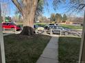 A view outside, showing a tree and several cars through a wooden fence at 4505 Everett St, Wheat Ridge, CO 80033