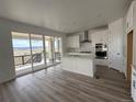 Bright kitchen with white cabinets, an island and stainless steel appliances, with an open view to the back patio at 8840 Whiteclover St, Littleton, CO 80125