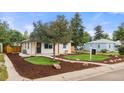 Home's inviting exterior, featuring a well-kept lawn, mulch accents, and a charming walkway at 3287 S Humboldt St, Englewood, CO 80113