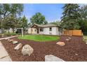 Well maintained home with an inviting front yard featuring manicured landscaping and a stone walkway at 3287 S Humboldt St, Englewood, CO 80113