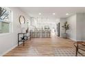 Bright, open concept living space with light hardwood floors seamlessly connecting to the modern kitchen at 3287 S Humboldt St, Englewood, CO 80113