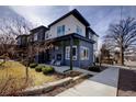 Contemporary home featuring a stone facade, porch with an outdoor fireplace and landscaped yard at 3003 S Sherman St, Englewood, CO 80113