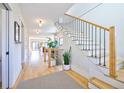 Inviting foyer with hardwood floors, staircase with black iron railing, and view into the home's open floorplan at 2182 S Ogden St, Denver, CO 80210