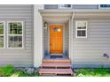 Inviting entryway featuring a colorful wooden front door, sidelight, and covered porch at 6904 Sprucedale Pkwy, Evergreen, CO 80439