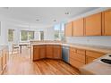 Bright eat-in kitchen with wooden cabinets, stainless steel dishwasher and hardwood floors at 6904 Sprucedale Pkwy, Evergreen, CO 80439