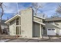 View of a home with a prominent chimney and a one-car garage, set beneath a partially cloudy sky at 9551 E Chenango Ave, Greenwood Village, CO 80111