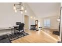 Sunlit living room with vaulted ceiling, hardwood floors, contemporary lighting, and modern furnishings at 9551 E Chenango Ave, Greenwood Village, CO 80111