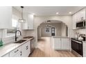 Bright kitchen featuring white cabinets, stone countertops, stainless appliances and tile backsplash at 2200 Fenton St, Edgewater, CO 80214
