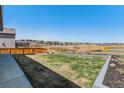 Large backyard with wooden fence, healthy grass, and beautiful landscaping at 89 Clara Pl, Castle Pines, CO 80108