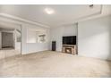 Bright living room featuring neutral walls, carpeted floors and a cozy fireplace for a comfortable living space at 12921 E 108Th Way, Commerce City, CO 80022