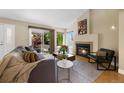 Cozy living room with a fireplace and sliding glass door to patio at 150 Blue Spruce Ct, Highlands Ranch, CO 80126
