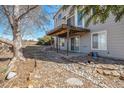 View of covered patio from backyard showing privacy fence and mature trees at 10765 Willow Reed Ct, Parker, CO 80134