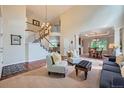 Bright living room boasts a staircase, hardwood floors, and seamlessly connects to the dining area at 10472 Longleaf Dr, Parker, CO 80134