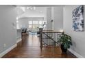 Light-filled entryway with hardwood floors flows into the living room and showcases staircase with wood railing at 9060 Ferncrest St, Firestone, CO 80504