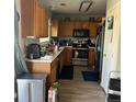 Kitchen features wooden cabinets, stainless steel appliances and laminate flooring at 15603 E 51St Pl, Denver, CO 80239