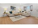Bright living room features wood floors, a large window, and neutral furniture for a comfortable and inviting space at 9639 W 63Rd Pl, Arvada, CO 80004