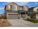 Classic two-story home with a front porch and a two-car garage, perfect for Gathering living at 821 Boulder Peak Ave, Erie, CO 80516