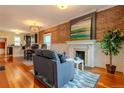 Cozy living room with hardwood floors, brick accent wall, and a decorative fireplace at 132 Delaware St, Denver, CO 80223
