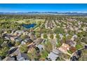 Breathtaking aerial view showcasing the neighborhood, a tranquil pond, and majestic mountains in the distance, creating a serene backdrop at 10963 Bryant St, Westminster, CO 80234