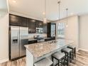 Well-lit kitchen boasts stainless steel appliances, an island with a countertop, and pendant lighting at 11902 Norfolk Ct, Commerce City, CO 80022