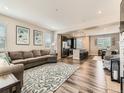 Spacious living room area that opens to the kitchen with wood floors and lots of natural light at 11902 Norfolk Ct, Commerce City, CO 80022