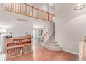 Bright foyer with hardwood floors, staircase, and a view into the dining room at 3186 W Indian Summer Ln, Castle Rock, CO 80109