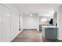 Bright living room with hardwood floors, a ceiling fan, an adjacent kitchen, and white walls for a modern look at 2800 Kalmia Ave # C101, Boulder, CO 80301