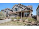 Charming two-story home featuring stone accents, gray siding, covered entry and a two car garage at 7121 W Asbury Pl, Lakewood, CO 80227