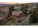 Aerial view of a home with a spacious backyard, large wooden deck, and lush landscaping at 12427 W Arkansas Ave, Lakewood, CO 80228