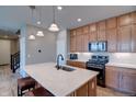 Open-concept kitchen boasting a large island with seating, stainless appliances, and wood cabinets at 21944 E Quincy Cir, Aurora, CO 80015