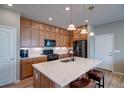 Modern kitchen featuring stainless steel appliances, island, and wooden cabinets at 21944 E Quincy Cir, Aurora, CO 80015
