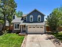 Beautiful two-story home featuring a well-maintained lawn, brick accents, and an attached two-car garage at 8680 Apache Plume Dr, Parker, CO 80134