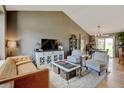 Cozy living room features vaulted ceilings, stylish decor, and a seamless flow into the dining area at 8680 Apache Plume Dr, Parker, CO 80134