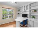Bright home office features custom built-ins, work desk and large window overlooking front yard at 5434 S Rome St, Aurora, CO 80015