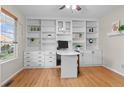 Bright home office with custom built-in shelving, drawers, and a sleek, curved desk for a functional workspace at 5434 S Rome St, Aurora, CO 80015