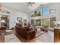 Bright living room with vaulted ceilings, large windows, and a cozy fireplace at 533 Tenderfoot Dr, Larkspur, CO 80118