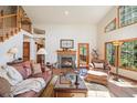 Inviting living room featuring a stone fireplace, vaulted ceilings, and natural light at 533 Tenderfoot Dr, Larkspur, CO 80118