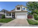 Inviting two-story home featuring a red front door, a balcony, and a well-maintained lawn at 5757 W Alamo Dr, Littleton, CO 80123