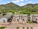 Panoramic aerial view of the townhome complex nestled against a backdrop of lush green mountains and trees at 114 Vale St, Palmer Lake, CO 80133