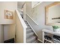 Inviting entryway with a staircase leading to the upper level, decorated with a stylish mirror and hanging plants at 114 Vale St, Palmer Lake, CO 80133