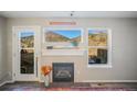 Living room featuring a cozy fireplace, scenic mountain views from windows, and a door to the outside at 114 Vale St, Palmer Lake, CO 80133