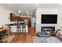 Open-concept living room with a modern fireplace and wood floors at 132 Ambrose St, Erie, CO 80516