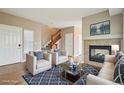 Inviting living room with a cozy fireplace, plush seating, and staircase at 12921 Grant Cir # B, Thornton, CO 80241